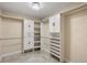 Walk-in closet with a decorative light fixture, custom cabinets, shelving, and closet rods at 7624 S Trenton Dr, Centennial, CO 80112