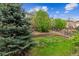 Backyard featuring a lush lawn, mature trees, terraced landscaping, and a wood fence at 22310 E Chenango Dr, Aurora, CO 80015