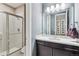 Bathroom featuring a glass shower, vanity with a sink and dark wood cabinetry and modern lighting at 22310 E Chenango Dr, Aurora, CO 80015