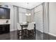 Dining area with a modern table, white chairs, and elegant window treatments at 22310 E Chenango Dr, Aurora, CO 80015