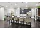 Bright kitchen featuring an expansive island with bar seating and dark hardwood floors at 22310 E Chenango Dr, Aurora, CO 80015