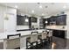 Modern kitchen with dark cabinetry, stainless steel appliances, and a large granite island with seating at 22310 E Chenango Dr, Aurora, CO 80015