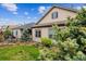 Side yard featuring lush lawn, mature trees, wood fence, and adjacent home exterior at 22310 E Chenango Dr, Aurora, CO 80015