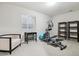 Bright workout room featuring a desk, elliptical machine, shelving, and comfortable chair by a window at 22310 E Chenango Dr, Aurora, CO 80015
