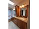 Lavish bathroom featuring skylight, soaking tub, dual sinks, granite countertops, and wood cabinetry at 5151 S Laredo Ct, Centennial, CO 80015