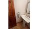 Charming powder room featuring pedestal sink with modern fixtures, wood flooring, and towel holder at 5151 S Laredo Ct, Centennial, CO 80015
