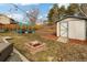 Backyard featuring fire pit, wooden storage shed, and pergola with seating, creating cozy gathering spots at 9605 W David Ave, Littleton, CO 80128