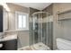 Bathroom with glass door shower, tile accents, modern vanity, and window for natural light at 9605 W David Ave, Littleton, CO 80128