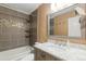 Well-lit bathroom with a tub, tiled shower, modern vanity, and large mirror at 9605 W David Ave, Littleton, CO 80128