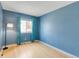 Bright bedroom featuring light blue walls, light wood flooring, and a large window at 9605 W David Ave, Littleton, CO 80128