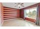 Bright bedroom with a ceiling fan, large window, and horizontal stripe accent wall at 9605 W David Ave, Littleton, CO 80128