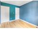 Bedroom with light blue walls, light wood floors, and two closets at 9605 W David Ave, Littleton, CO 80128