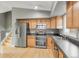 The kitchen features wooden cabinets, stainless steel appliances, including a double oven, and a window view at 9605 W David Ave, Littleton, CO 80128