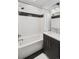 Modern bathroom with a clean white tub, black and white tile accents, and a stylish vanity with gold hardware at 25 S Washington St # 2, Denver, CO 80209