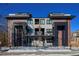 Modern townhome exterior showcasing balconies, a fenced yard, and contemporary architectural details under a clear blue sky at 25 S Washington St # 2, Denver, CO 80209