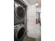 Convenient laundry area featuring stacked washer and dryer, adjacent to a bedroom at 25 S Washington St # 2, Denver, CO 80209