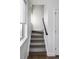 Bright staircase with neutral carpet and a sleek black handrail leading to the upper level of the home at 25 S Washington St # 2, Denver, CO 80209