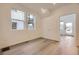 Bright bedroom with wood-look floors and natural light; with view to street and a doorway into the room at 7308 Waterleaf Trl, Littleton, CO 80125