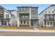 Modern two-story home with gray siding and stone accents, complemented by well-manicured landscaping at 7308 Waterleaf Trl, Littleton, CO 80125