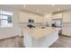 Well-lit kitchen featuring white cabinets, stainless steel appliances, and a large center island at 7308 Waterleaf Trl, Littleton, CO 80125