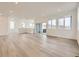 Spacious living room with wood-look floors, recessed lighting, and ample natural light at 7308 Waterleaf Trl, Littleton, CO 80125