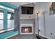 Cozy fireplace with a mounted TV, complemented by a unique floor lamp and natural light at 17478 E Rice Cir # D, Aurora, CO 80015