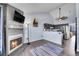 Open-concept living space with a fireplace, adjacent kitchen, and modern decor at 17478 E Rice Cir # D, Aurora, CO 80015