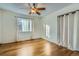 Comfortable bedroom featuring gleaming hardwood floors, bright window, and a ceiling fan at 9088 W 88Th Cir, Westminster, CO 80021