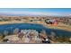 Stunning aerial view of community clubhouse, showcasing its recreational lake and ample parking area at 18039 E 108Th Pl, Commerce City, CO 80022