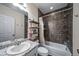 Bathroom with granite-topped vanity and shower-tub with dark-tiled surround and shower caddy at 18039 E 108Th Pl, Commerce City, CO 80022
