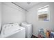 Practical laundry room equipped with a washer, dryer, and shelving for storage, making laundry tasks easier at 18039 E 108Th Pl, Commerce City, CO 80022