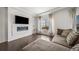 Stylish living room featuring a modern electric fireplace with stone surround and large windows at 18039 E 108Th Pl, Commerce City, CO 80022
