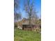 Backyard view of quaint brick home, featuring mature trees, lush green grass and a glimpse of mountain views at 1914 Washington Ave, Golden, CO 80401