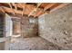Unfinished basement with exposed beams, stone walls, and a small window, offering potential for customization at 1914 Washington Ave, Golden, CO 80401