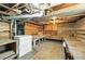 Unfinished basement with wooden support beams, storage shelving, and a laundry area, awaiting transformation at 1914 Washington Ave, Golden, CO 80401