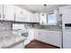 Bright kitchen with white cabinets, tile backsplash, granite countertops, and stainless steel appliances at 8666 Decatur St # 254, Westminster, CO 80031