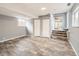 Finished basement with wood-look floors, two closets, and staircase at 825 S Quitman St, Denver, CO 80219
