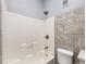 Bright bathroom with a tiled shower and tub combo plus modern fixtures at 825 S Quitman St, Denver, CO 80219