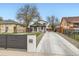 Charming home featuring a long driveway, dark trim, and a manicured front yard at 825 S Quitman St, Denver, CO 80219