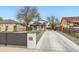 Charming home exterior featuring a long driveway and well-maintained landscaping at 825 S Quitman St, Denver, CO 80219