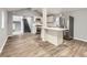 Open kitchen and living area featuring new floors, grey paint, and modern appliances at 825 S Quitman St, Denver, CO 80219