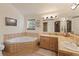 Bright bathroom featuring a soaking tub with tile surround, and double sink vanity with tile countertop at 493 Cr 672, Breckenridge, CO 80424