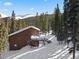 Charming cabin with a snow-covered roof nestled in a serene mountain setting, surrounded by tall trees at 493 Cr 672, Breckenridge, CO 80424