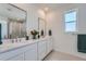 Bright bathroom featuring double sinks, modern mirrors, and sleek countertops at 938 Hearteye Trl, Lafayette, CO 80026