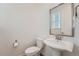 Bathroom features a pedestal sink, modern fixtures, and bright lighting at 938 Hearteye Trl, Lafayette, CO 80026