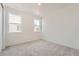 Bright and airy bedroom with plush carpet, two windows, and neutral color palette at 938 Hearteye Trl, Lafayette, CO 80026