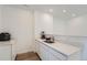 A well-lit kitchen area features sleek, white cabinetry and modern appliances at 938 Hearteye Trl, Lafayette, CO 80026