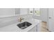 Modern kitchen sink with stainless steel fixtures and light countertops by the window at 938 Hearteye Trl, Lafayette, CO 80026