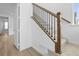 Elegant staircase featuring wood railings, black spindles, and plush carpet treads at 938 Hearteye Trl, Lafayette, CO 80026