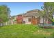 Green backyard featuring solar panels, a hot tub, privacy fencing, patio, and a trampoline at 23882 E Alabama Dr, Aurora, CO 80018
